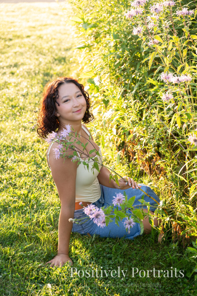 Emerson standing in a field of wildflowers at Brunswick Lake Park, early morning sunlight creating a dreamy glow around her.
