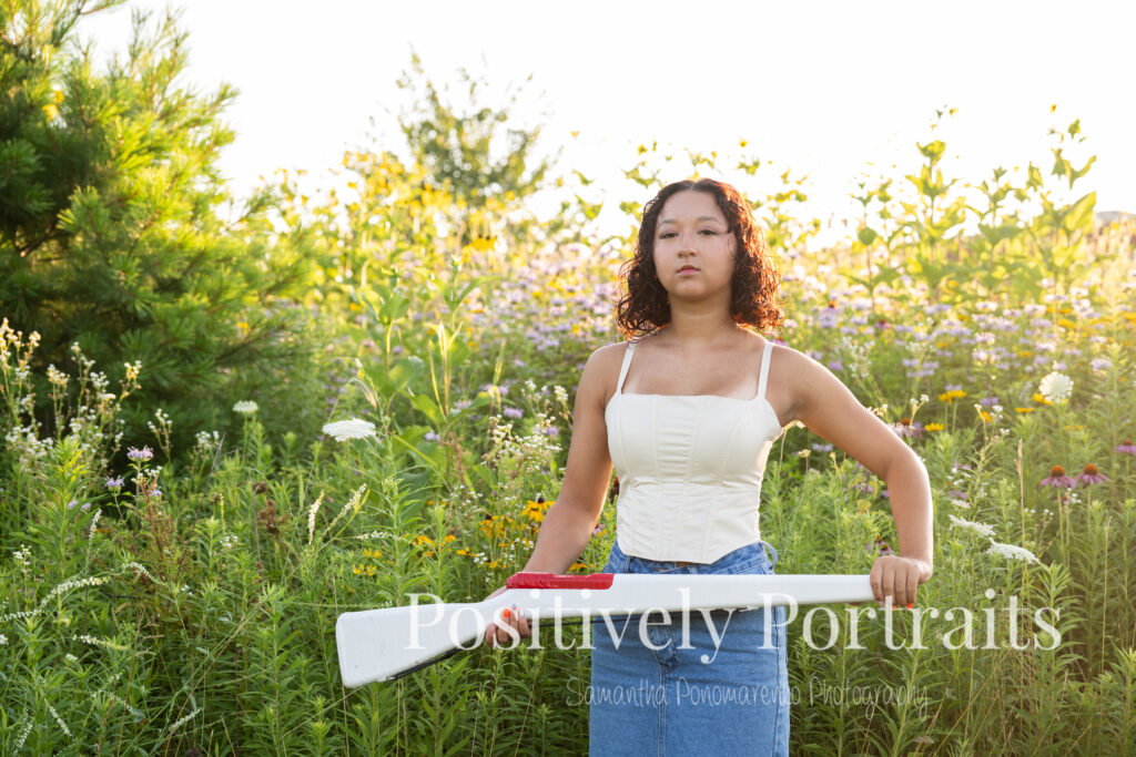 Emerson standing in a field of wildflowers at Brunswick Lake Park, early morning sunlight creating a dreamy glow around her.