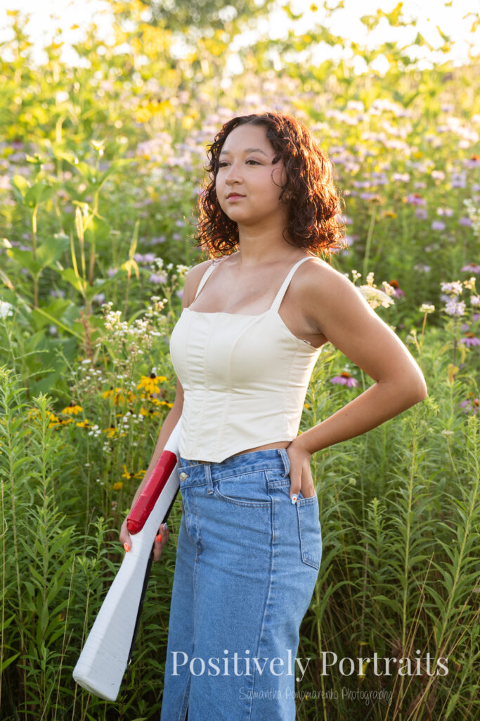 Emerson standing in a field of wildflowers at Brunswick Lake Park, early morning sunlight creating a dreamy glow around her.