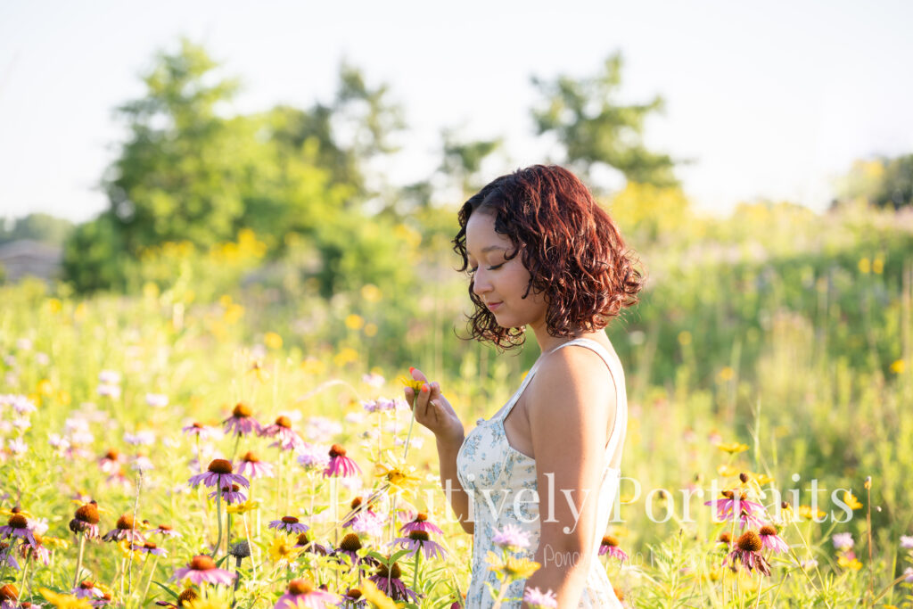 Emerson standing in a field of wildflowers at Brunswick Lake Park, early morning sunlight creating a dreamy glow around her.