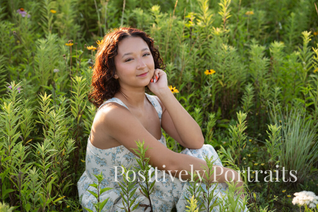 Emerson standing in a field of wildflowers at Brunswick Lake Park, early morning sunlight creating a dreamy glow around her.