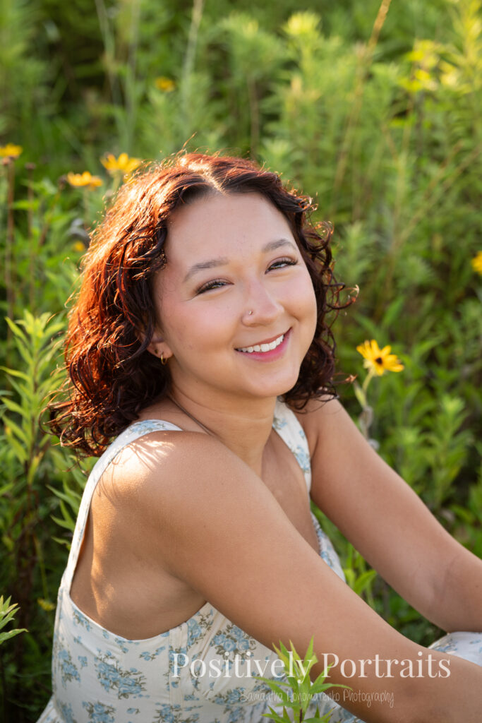 Emerson standing in a field of wildflowers at Brunswick Lake Park, early morning sunlight creating a dreamy glow around her.