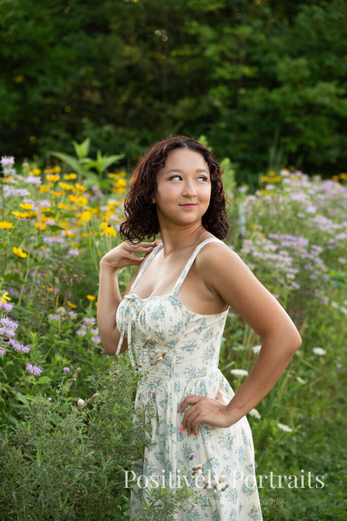 Emerson standing in a field of wildflowers at Brunswick Lake Park, early morning sunlight creating a dreamy glow around her.