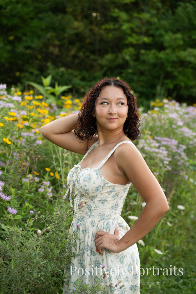 Emerson standing in a field of wildflowers at Brunswick Lake Park, early morning sunlight creating a dreamy glow around her.