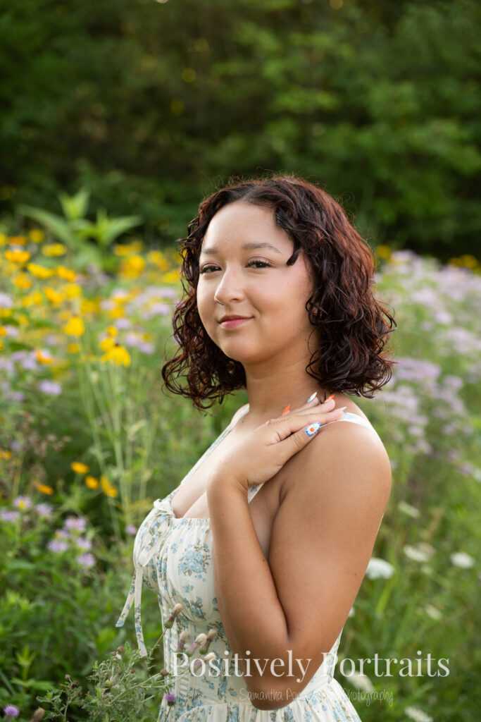 Emerson standing in a field of wildflowers at Brunswick Lake Park, early morning sunlight creating a dreamy glow around her.