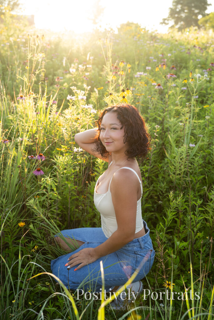 Emerson standing in a field of wildflowers at Brunswick Lake Park, early morning sunlight creating a dreamy glow around her.