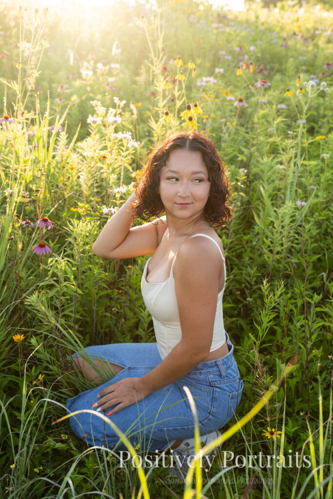 Emerson standing in a field of wildflowers at Brunswick Lake Park, early morning sunlight creating a dreamy glow around her.